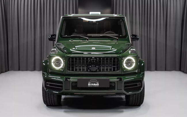 A picture of a 2023 Mercedes-Benz G63 in olive color driving on a mountain road